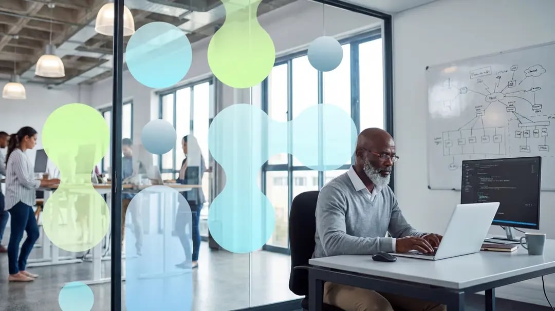 IT professional in glass meeting room with whiteboard showing network architecture diagrams