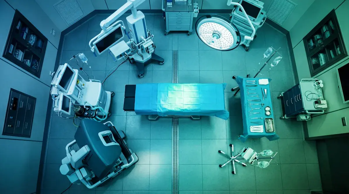 verhead view of a hospital operating room with connected medical devices, patient monitors, and surgical equipment